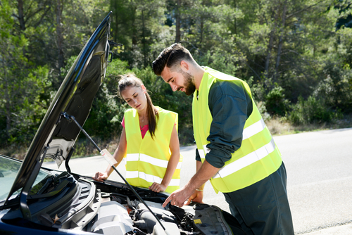 young woman and mechanic assistance on roadside after car breakdown young woman and mechanic assistance on roadside with car breakdown